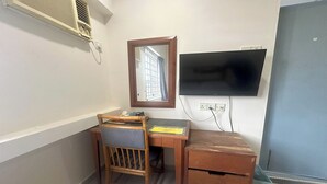 A small room with a desk, chair, and a television mounted on the wall. - Angsa Hotel (Seremban)