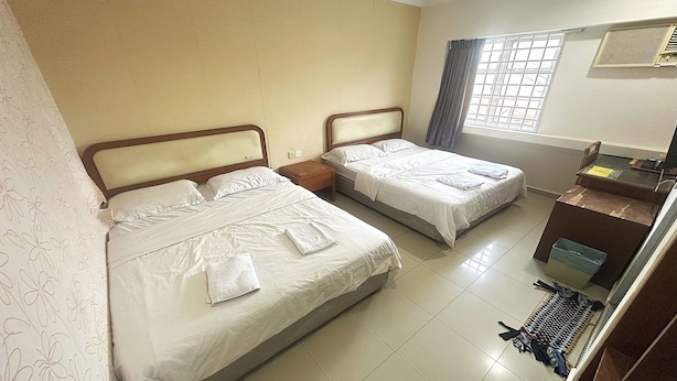 A hotel room with two beds, a desk, and a window with curtains. - Angsa Hotel (Seremban)