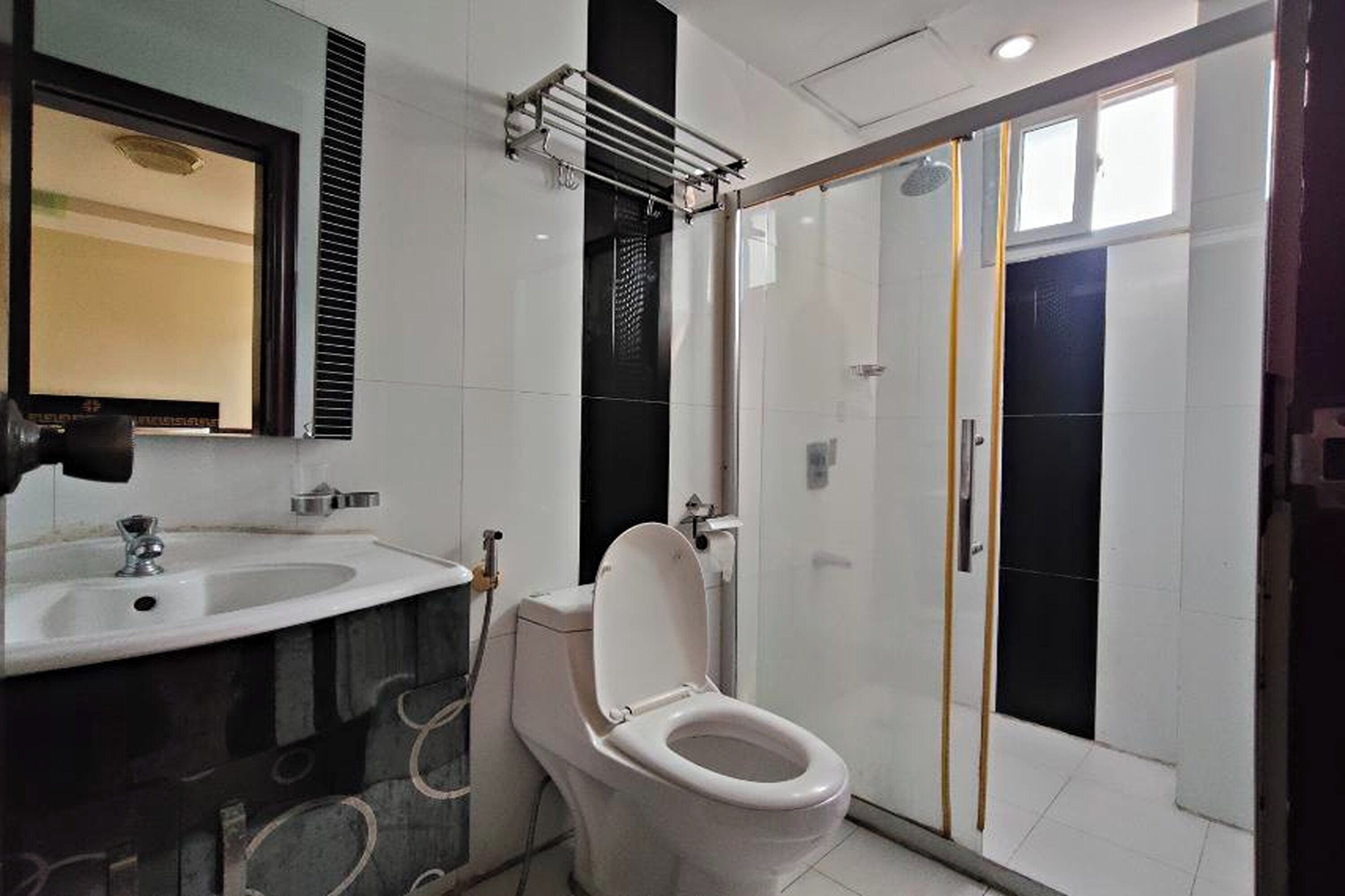 Une salle de bain moderne équipée de toilettes, d’un lavabo et d’une douche.