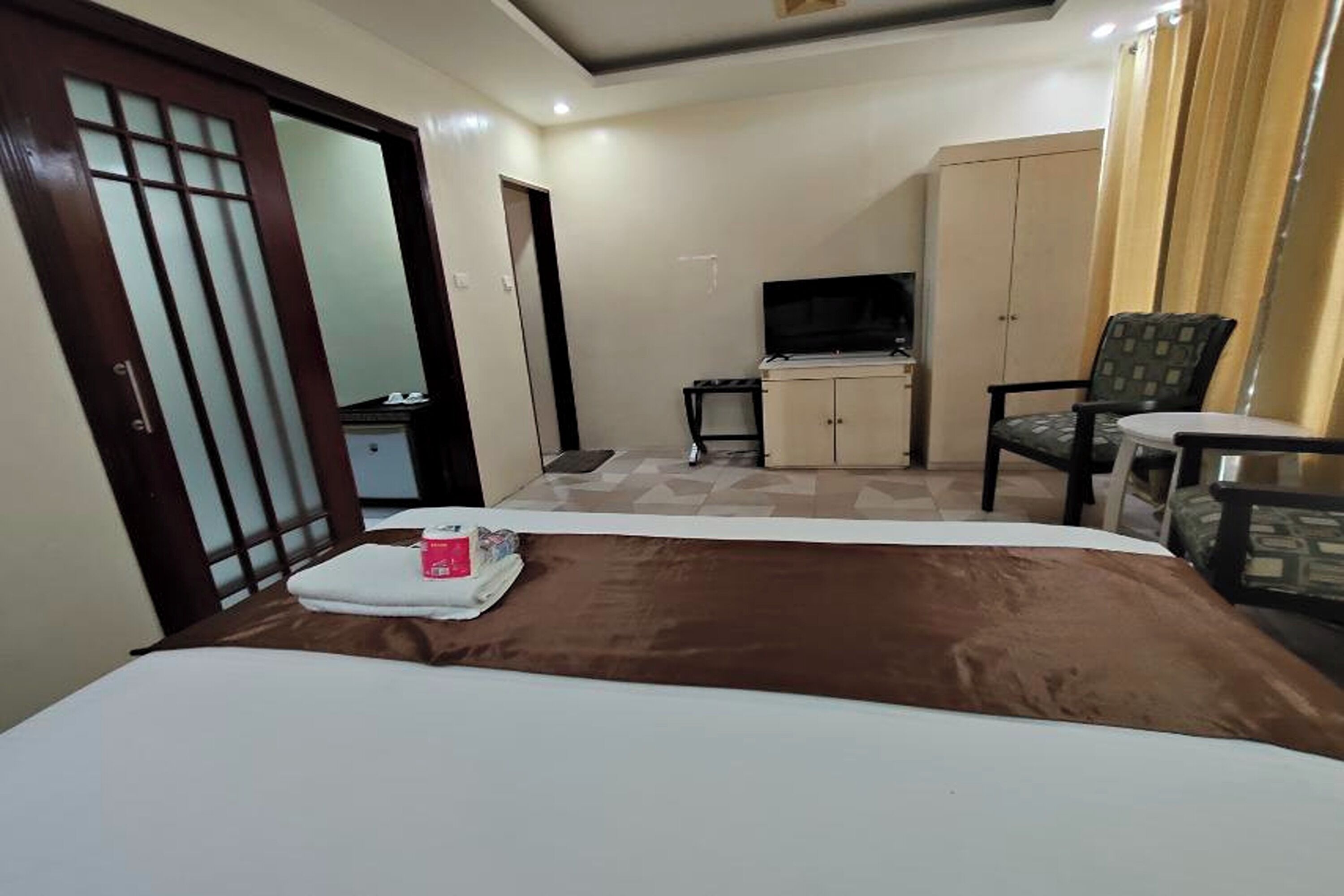 Une chambre d’hôtel équipée d’un lit, d’une télévision, d’un bureau et d’une armoire.