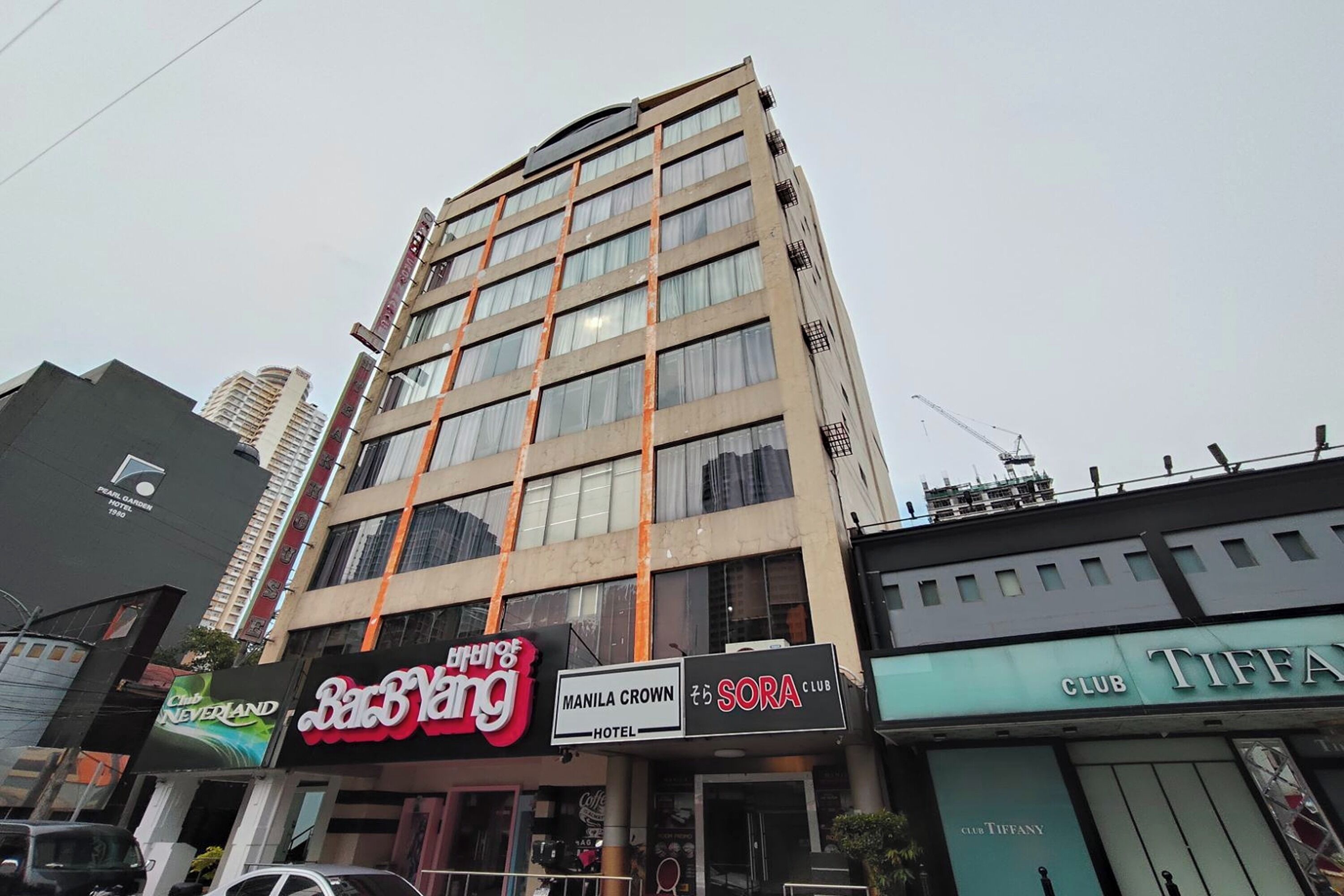 Un edificio de varios pisos con diversos comercios en la planta baja, incluyendo un hotel y un club.