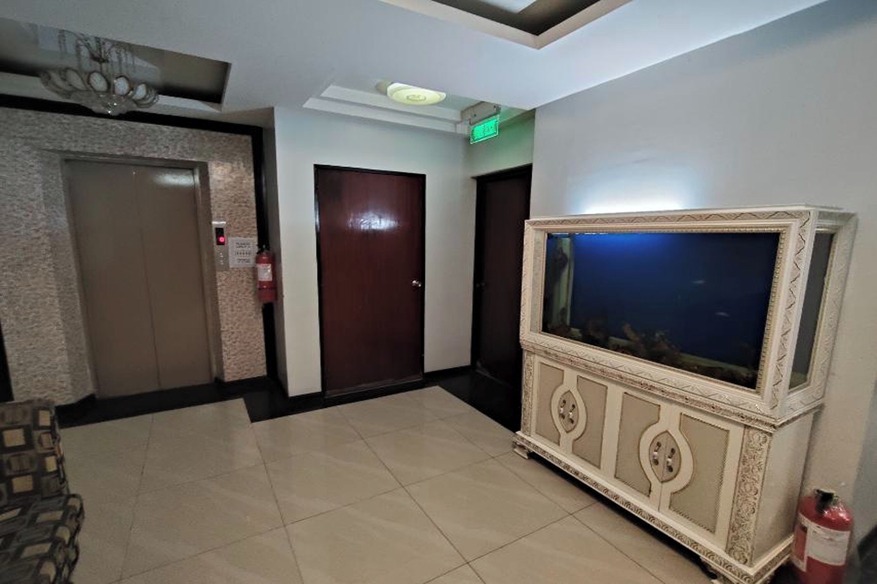 Un hall d’entrée avec un comptoir de réception, un grand aquarium et un extincteur.