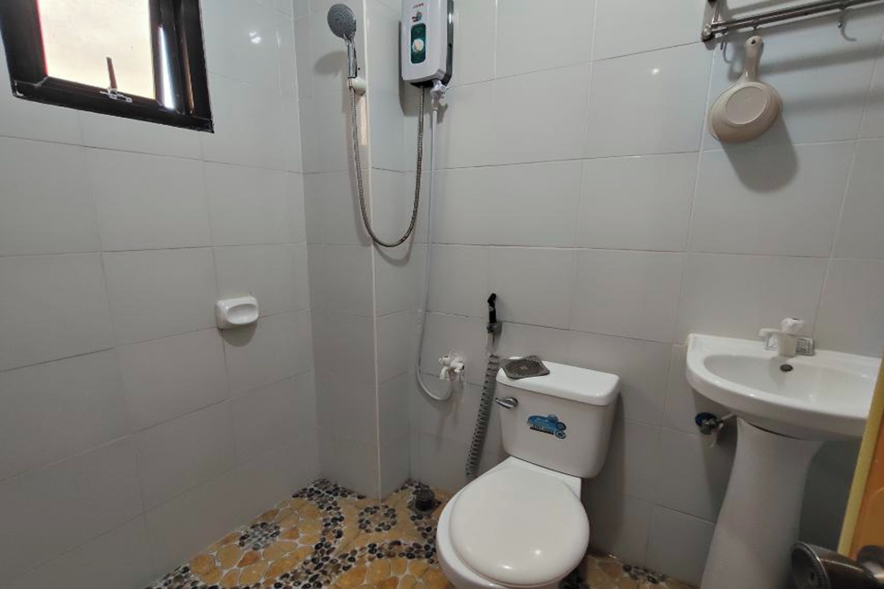 Un baño pequeño con inodoro, lavamanos y ducha.