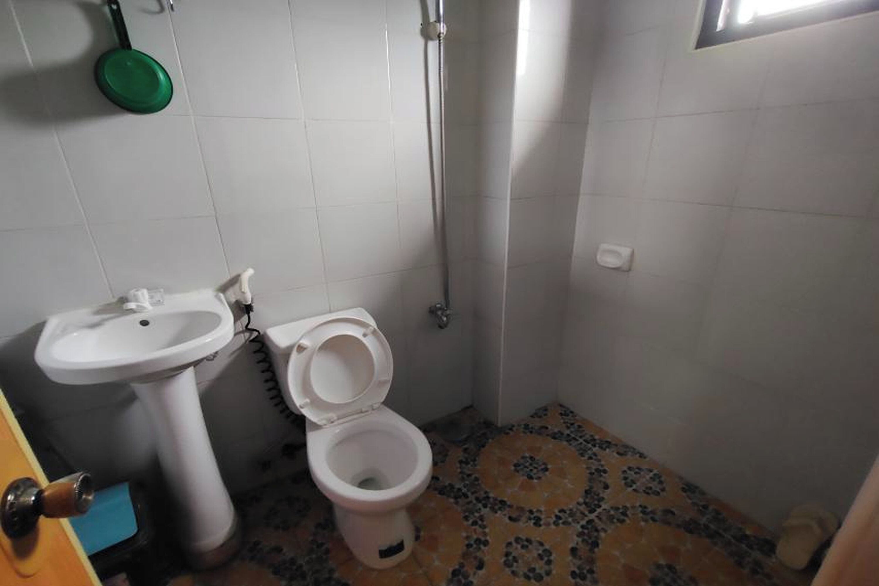 A small bathroom with a toilet, sink, and shower.