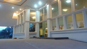 Un edificio moderno con ventanas amplias, una escalera y un candelabro.