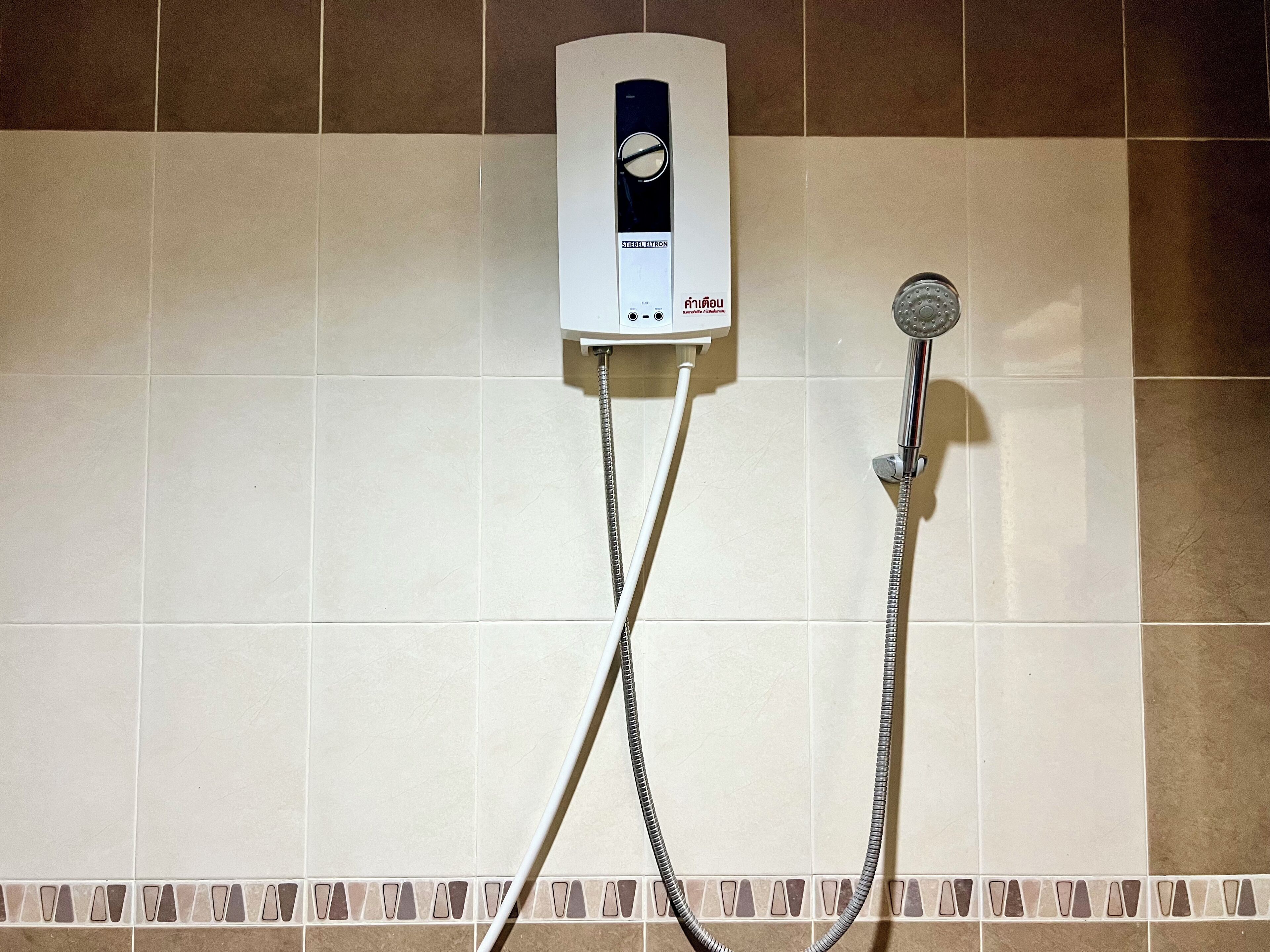 Un panel de control de ducha con cabezal de ducha de mano.