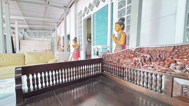 A room with a wooden bench, a sofa, and a decorative wall with carvings. - Sunshiny-BB Hostel near Punnavithi BTS station (Bangkok)