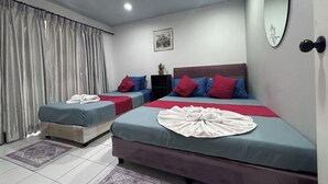 A hotel room with two beds, a large mirror, and a small table with a plant. - Sunshiny-BB Hostel near Punnavithi BTS station (Bangkok)