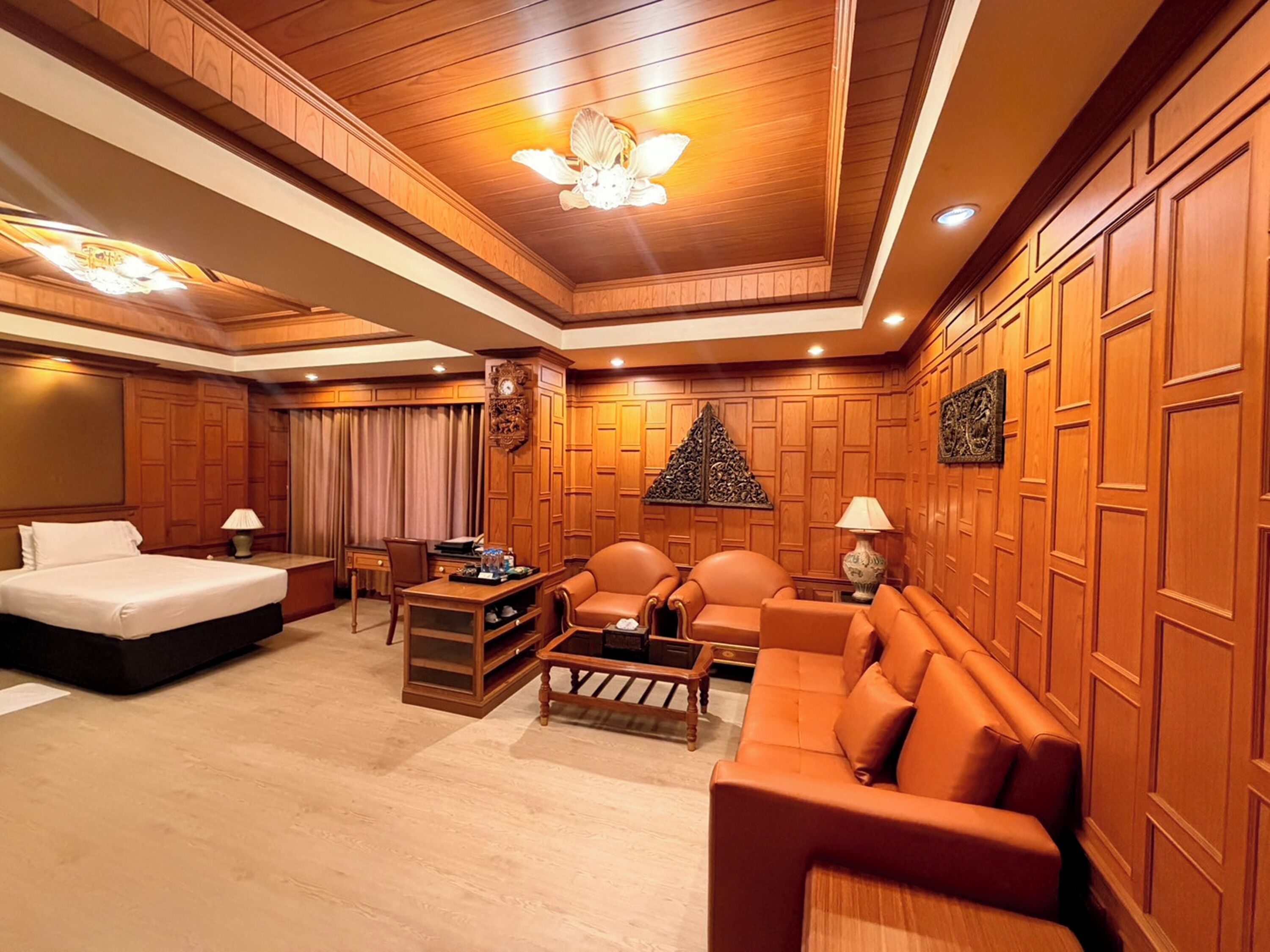 Ein Hotelzimmer mit Bett, Sofa, Couchtisch und Schreibtisch mit Stuhl.