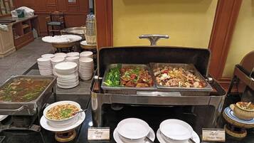 A buffet setup with various dishes and labeled serving utensils.