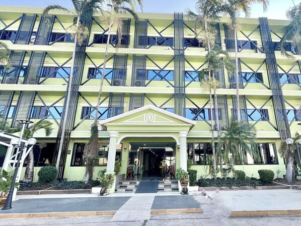 A multi-story hotel with a symmetrical facade, large windows, and a central entrance with steps. - New Siya Hotel (Maha Sarakham)