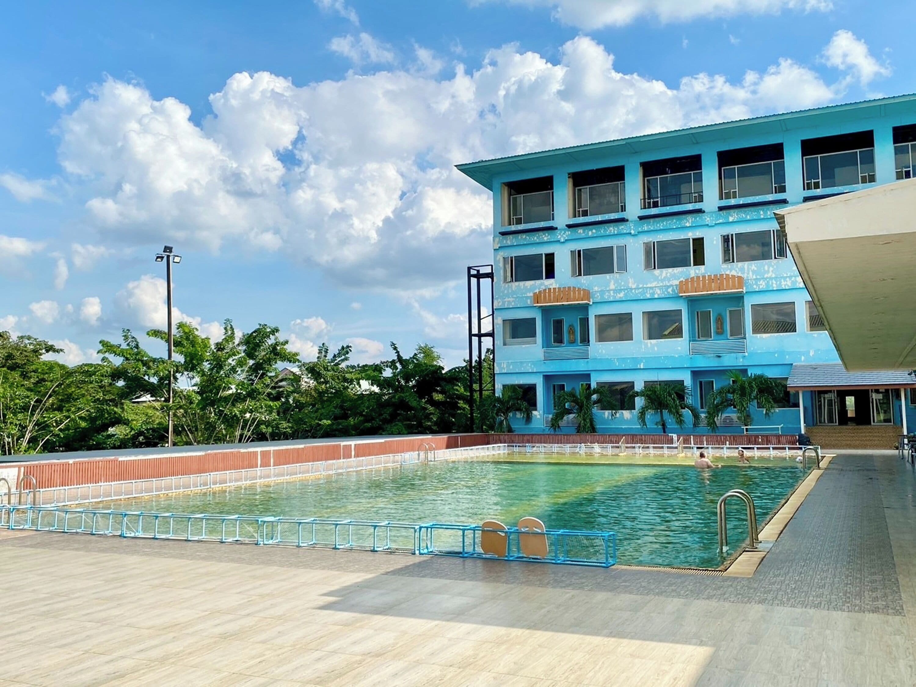 A swimming pool with a blue building in the background.