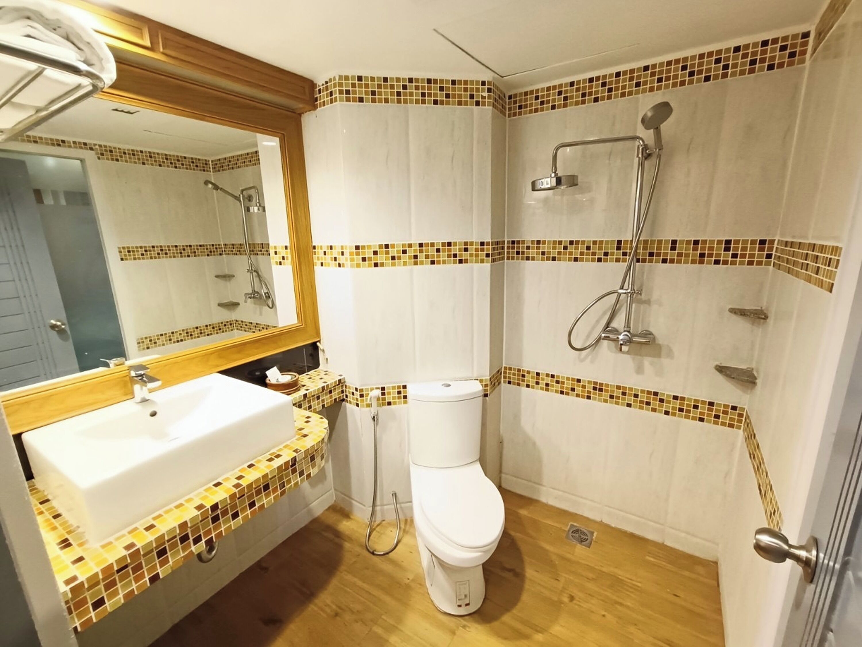 A bathroom with a white sink, toilet, and shower.