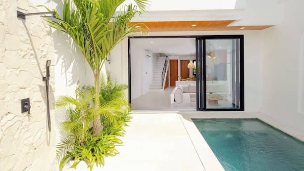 A modern house with a swimming pool, a staircase, and a glass door leading to a living area. - Villa Amal 9 by Pertama Stay (Canggu)