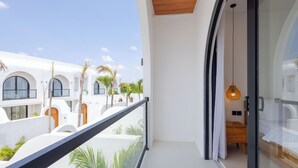 A modern hotel room with a balcony, white walls, and a wooden ceiling. - Villa Amal 9 by Pertama Stay (Canggu)