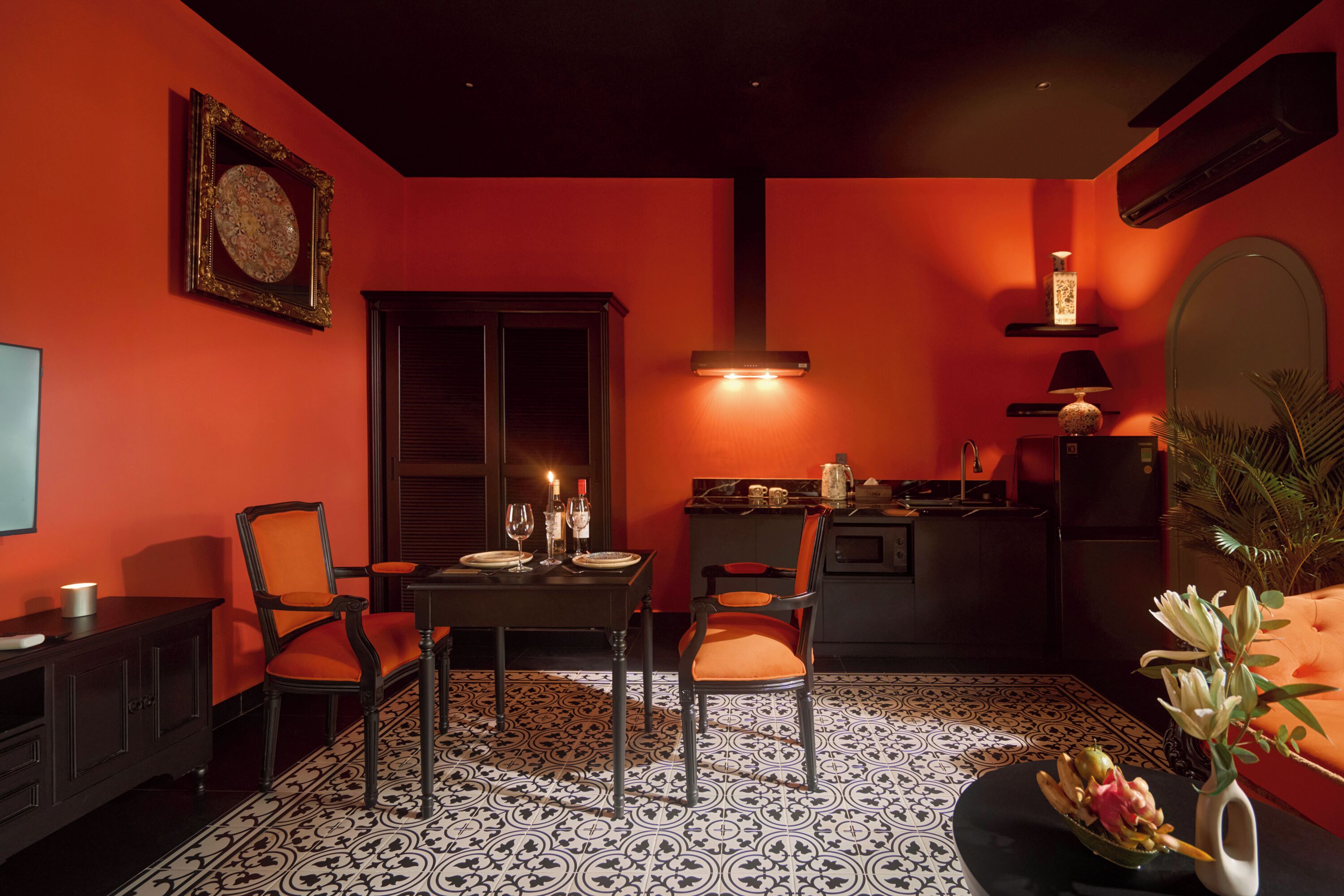 Un comedor con una mesa dispuesta para dos personas, una silla, un armario y un jarrón decorativo con flores.