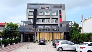 Un edificio de varios pisos con un letrero que dice "PRITHVI RESORT" en la entrada.