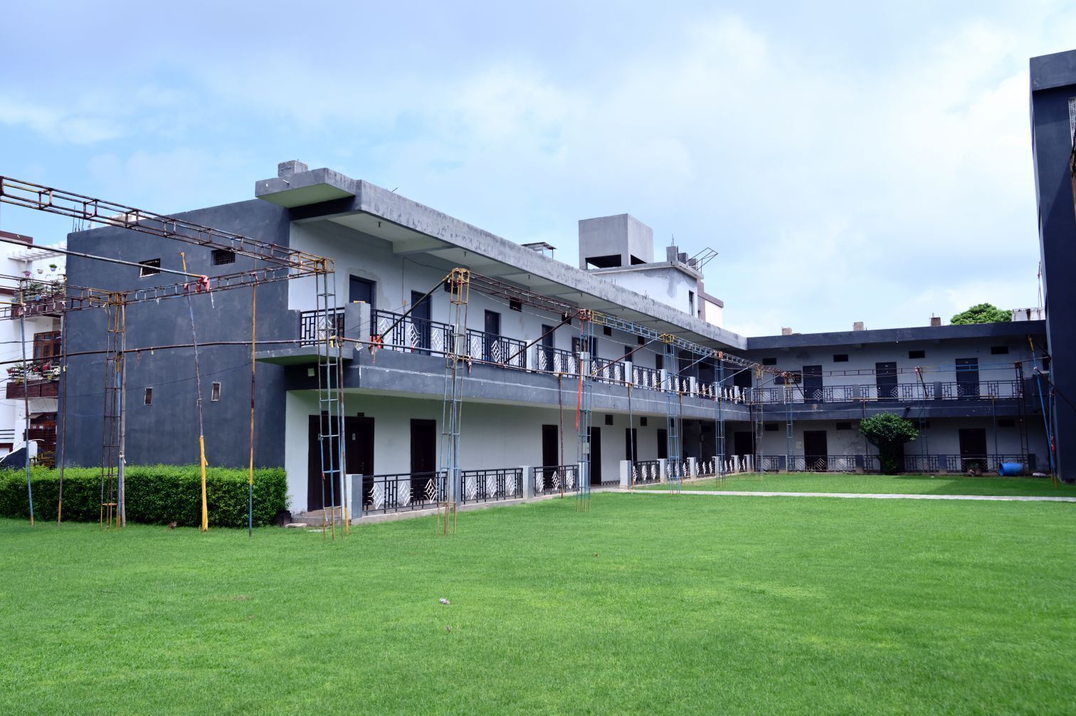 A multi-story building with a flat roof, balconies, and a covered outdoor area.
