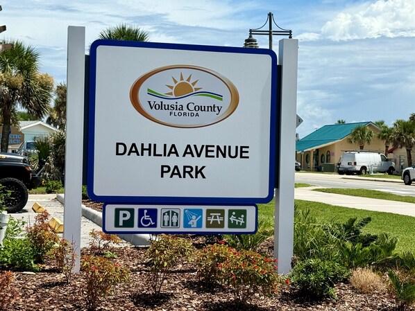 A sign for Volusia County Florida Dahria Avenue Park with parking and accessibility symbols.