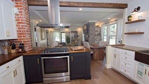 A modern kitchen with a central island, built-in oven, and white cabinetry.