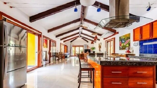 A spacious kitchen with high ceilings, wooden beams, a large island, and modern appliances. - Villa con Piscina y Acceso a Laguna Yalkú, Akumal (Akumal)