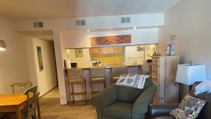 A compact living space with a kitchenette, a dining area, a sofa, and a small table. - Charming 1-bedroom condo in Frisco (Frisco)