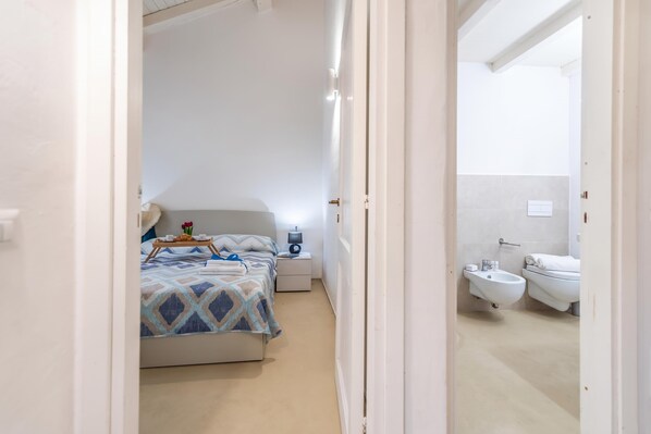 A bedroom with a bed, bedside table, and a nightstand. - Rotondo Dream Suite 1, Porto Rotondo, Italy (Porto Rotondo)