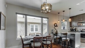 Una cocina moderna con comedor, ventanas amplias y fachada de piedra.