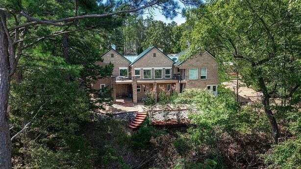 A two-story house with a stone facade, large windows, and a balcony. - Peaceful Retreat w/Lakeview in Hot Springs Village (Hot Springs Village)