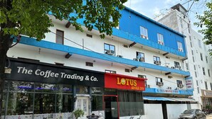 A building with a coffee shop named "The Coffee Trading & Co." and a hotel named "Lotus Hotels Inn." - Lotus Hotel Inn (Varanasi)