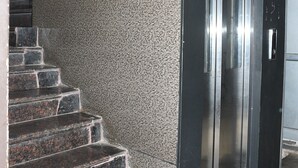 A staircase leading to a metallic elevator door. - Lotus Hotel Inn (Varanasi)