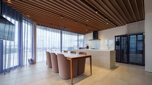 A modern kitchen with a central island, large windows, and a slatted ceiling. - lili villa hayama (Hayama)