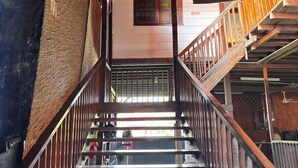 A wooden staircase with a metal handrail, leading to an upper floor. - Audi Guest House (George Town)