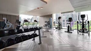 A modern gym with treadmills, elliptical machines, and free weights.