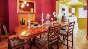 Comedor con mesa de madera, sillas y una araña.