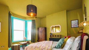 Un dormitorio con cama, ventana, armario y espejo.