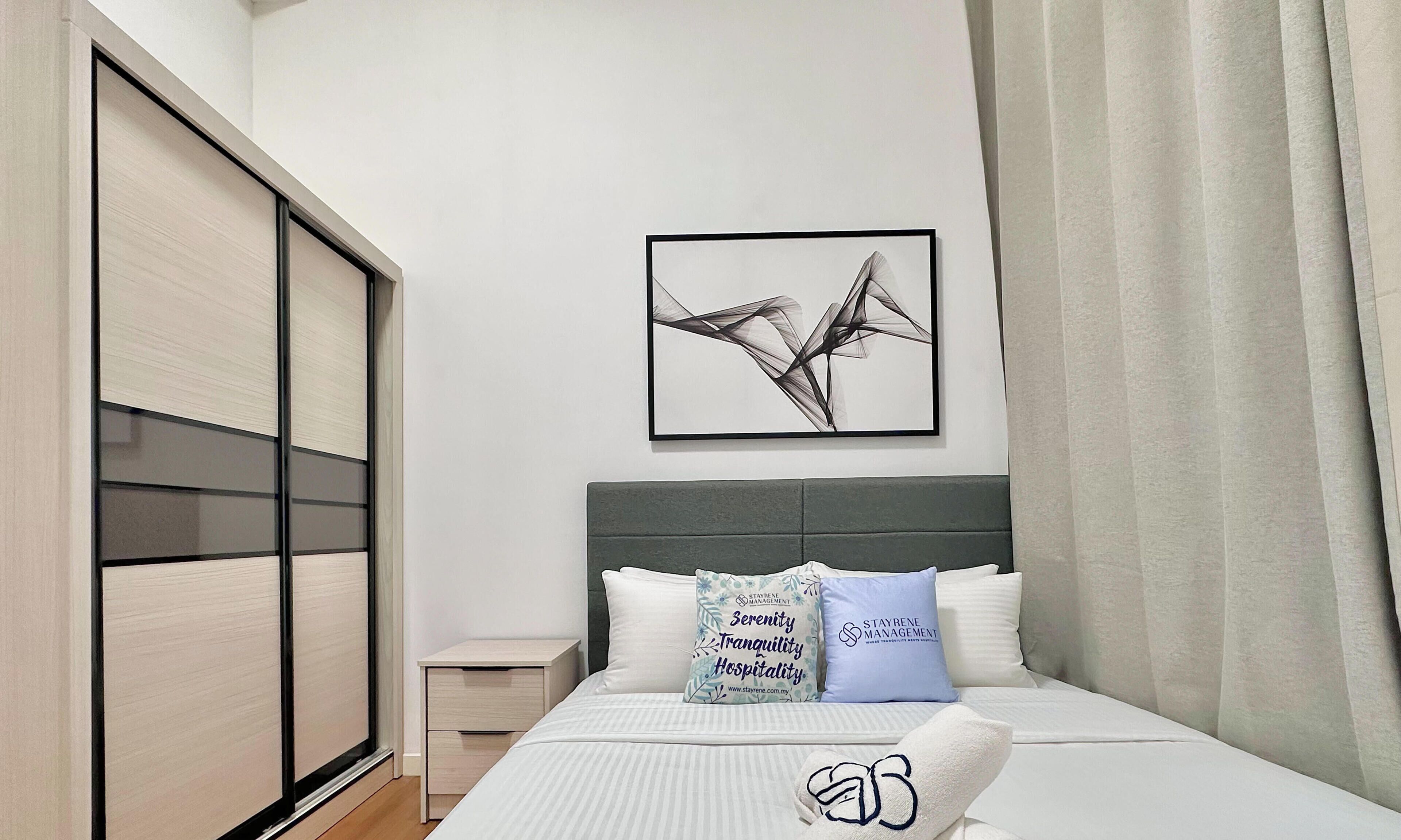 Una habitación de hotel moderna con una cama grande, una mesita de noche, un armario y una obra de arte enmarcada en la pared.