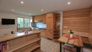 Eine moderne Küche mit Holzausstattung, einem Einbauofen und einem großen Fenster.