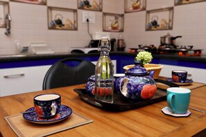 A dining table with a teapot, cups, and a tray. - Le Clarisse Guest House 2 (Puducherry)