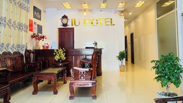 A hotel lobby with a reception desk, wooden furniture, and a ceiling fan. - IU Beach Hotel Phu Quoc (Phu Quoc)