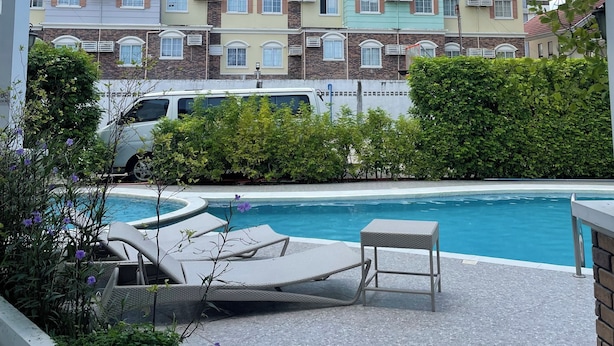 A residential building with multiple balconies, a swimming pool, and a parked van.