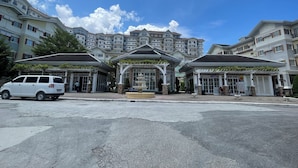 A hotel with a central fountain, multiple balconies, and a parking area.