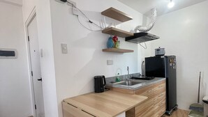 A modern kitchen with a wooden countertop, built-in appliances, and a small island with seating.