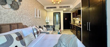Une chambre à coucher avec un grand lit, un canapé, un lustre et une armoire.
