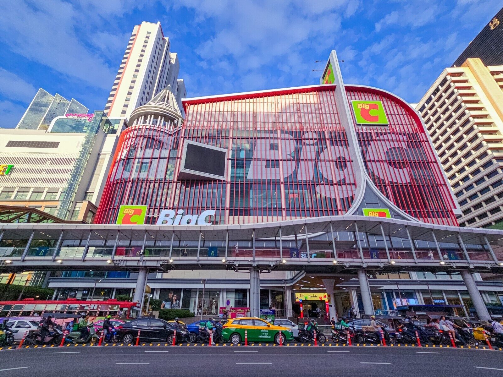 A modern building with a prominent 'Big C' sign, featuring a curved facade and a large digital display.