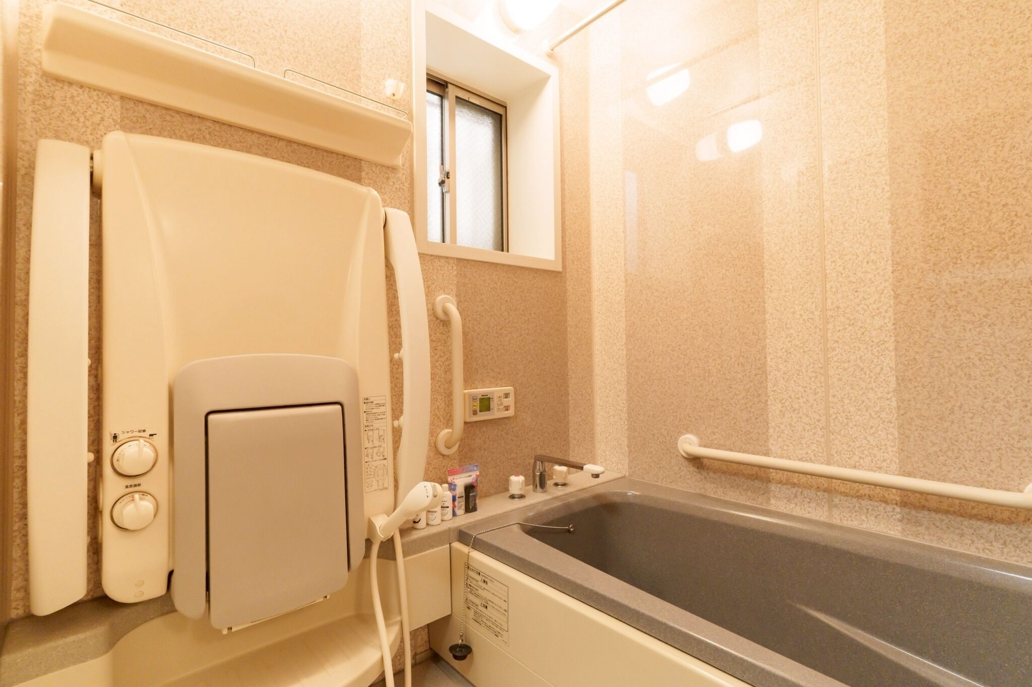 A bathroom with a bathtub, a shower area, and a window.