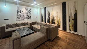 Una sala de estar moderna con un sofá modular, una mesa de centro y obras de arte urbano en las paredes.