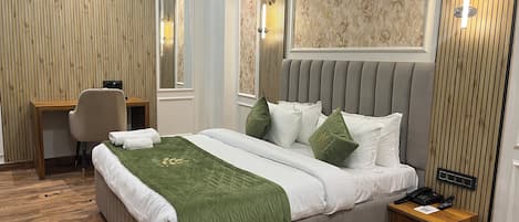 Une chambre bien rangée, avec un lit, une table de chevet et un bureau avec une chaise.