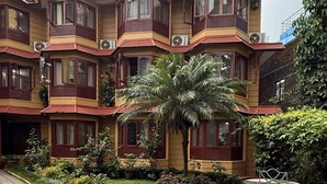 A multi-story building with a traditional architectural style, featuring balconies with red railings and multiple windows. - Laavanya Inn (Pokhara)