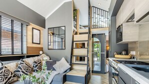 A modern interior with a living area, kitchen, and a loft bedroom with a staircase. - 2 bedroom accommodation in Chirk, near Llangollen (Chirk, near Llangollen)
